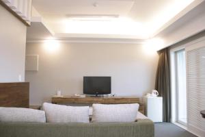a living room with a couch and a tv at Hotel Ocean View in Ulsan