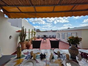 an outdoor patio with a table and chairs and cactus at Riad Patio des Amis Marrakech in Marrakesh