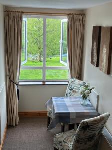a living room with a table and a window at The Hermitage Riverside House in Clogheen +45 photos