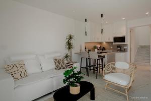 a living room with a white couch and a kitchen at Relaxury Villa II in Karpathos