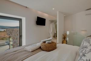 a bedroom with a bed with a tv and a window at Relaxury Villa II in Karpathos +15 photos