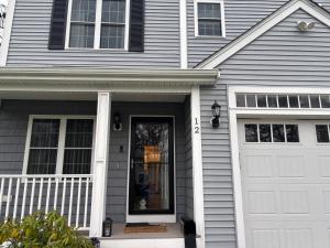 a white house with a white garage door at 12Birchwood in Holbrook