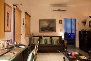 een woonkamer met een bank en een tafel bij Frangipani Penthouse in New Delhi