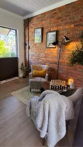 a living room with a couch and a brick wall at Studio 149 - Wild Coast Accommodation in Sunrise-on-Sea