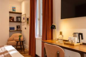 a room with a desk and a bed and a window at Europe Hotel Paris Eiffel in Paris