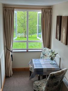 a living room with a table and a window at The Hermitage Riverside House in Clogheen