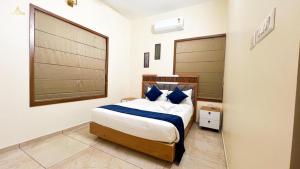 a bedroom with a bed with blue pillows at SafeStay Wayanad - 1BHK & 2BHK with Kitchen Facilities in Wayanad +24 photos