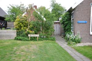 a yard with a sign in the grass next to a house at Het Voorhuis in Grolloo