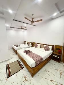 a bedroom with two beds and a ceiling fan at Hotel Shiva Darshanam in Varanasi