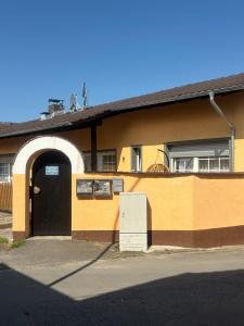 a yellow building with a black door and a window at Ferienwohnung Alex in Nidderau