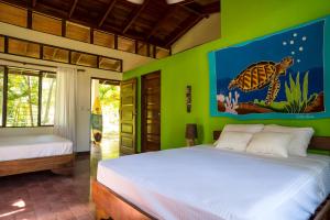 a bedroom with two beds and a turtle painting on the wall at Tides Oceanfront Resort in Santa Cruz