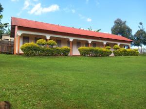 a building with a red roof and a green yard at Yasipi Cottages in Sipi