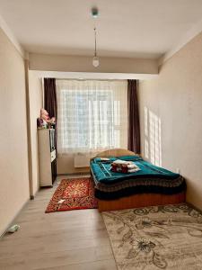 a bedroom with a bed and a window and a refrigerator at 3 room SUPERIOR APARTMENT at ELITE TOWER in downtown NURBIE'S TRAVEL in Ölgiy