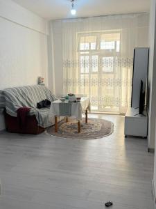 a living room with a bed and a table at 3 room SUPERIOR APARTMENT at ELITE TOWER in downtown NURBIE'S TRAVEL in Ölgiy