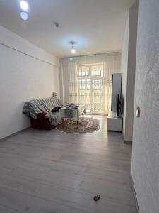 a living room with a couch and a table at 3 room SUPERIOR APARTMENT at ELITE TOWER in downtown NURBIE'S TRAVEL in Ölgiy