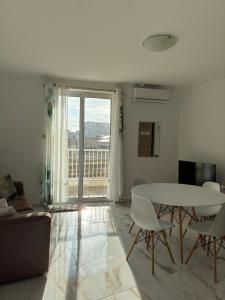 a living room with a white table and chairs at Il-Pitirross Apartment Gozo in Sannat