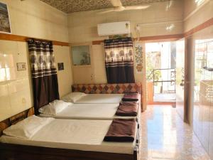 two twin beds in a room with a window at ADwarkesh femily homestay in Dwarka +11 photos