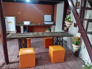 a kitchen with a table and some orange stools at "Casa de Piobeto" in Santa Ana