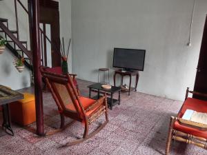 a living room with a flat screen tv and chairs at "Casa de Piobeto" in Santa Ana