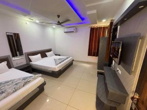 a room with two beds and a tv in it at Hotel Shekhawati Resort -Parking Restaurant Near Toran Dwar in Khātu