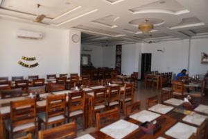 a large room with wooden tables and chairs at Hotel Shekhawati Resort -Parking Restaurant Near Toran Dwar in Khātu