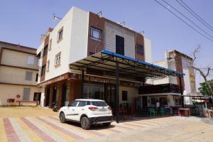 a white car parked in front of a building at Hotel Shekhawati Resort -Parking Restaurant Near Toran Dwar in Khātu