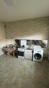 a kitchen with a stove and a washing machine at Aruzhan Hostel in Shymkent +22 photos