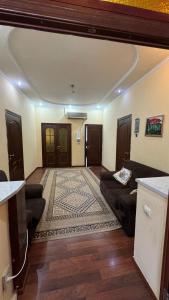 a living room with a couch and a rug at Aruzhan Hostel in Shymkent