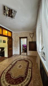 a living room with a rug on the floor at Aruzhan Hostel in Shymkent