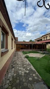 a stone walkway next to a building at Aruzhan Hostel in Shymkent
