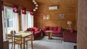 a living room with red couches and a table at Private Wood Cabin in Palanga