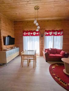 a living room with a red couch and a table at Private Wood Cabin in Palanga