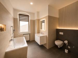 a bathroom with a sink and a toilet and a tub at Pension J&M in Meißen +10 photos
