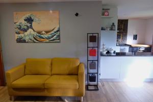 a living room with a yellow couch and a painting at El Cimblu in Gradura