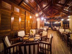 a restaurant with wooden walls and tables and chairs at Lodge Océan et Savane in Saint-Louis