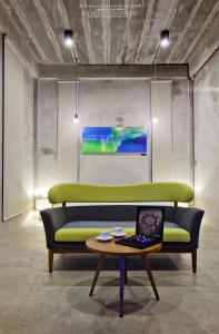 a green couch in a room with a laptop on a table at Twelve Oclock Resort in Si Khio