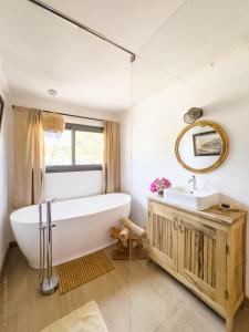 a bathroom with a tub and a sink and a mirror at Lodge Océan et Savane in Saint-Louis +21 photos