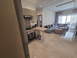 a kitchen and living room with a couch and a stove at Cozy apartment with pool view in Dar Hamida +15 photos