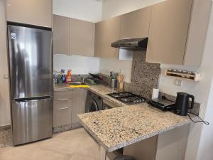 a kitchen with a stainless steel refrigerator and granite counter tops at Cozy apartment with pool view in Dar Hamida