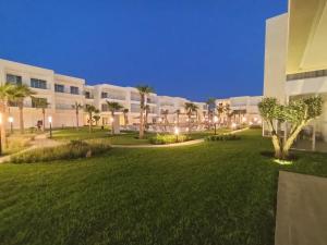a park in front of a building at night at Cozy apartment with pool view in Dar Hamida