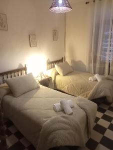 a bedroom with two beds with towels on them at Casa de los Abuelos in Cardeña