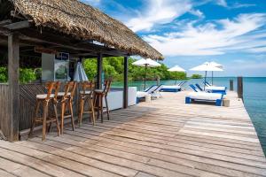 a wooden deck with chairs and umbrellas on the water at Bayside Island in Cartagena de Indias