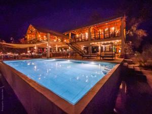 a swimming pool in front of a house at night at Lodge Océan et Savane in Saint-Louis