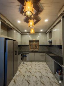 a kitchen with white cabinets and a ceiling with a chandelier at VIN Solara Farm Stay in Jaffna