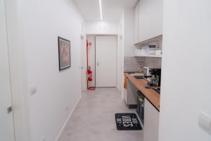 a kitchen with white walls and a red fire hydrant at Mythos House in SantʼAgata sui Due Golfi
