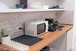 a microwave sitting on top of a wooden counter at Mythos House in SantʼAgata sui Due Golfi +39 photos