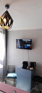 a living room with a tv on the wall at chambre Marseille pas lon de saint Charles et vieux port in Marseille