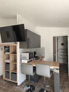 a kitchen with a table with two chairs and a microwave at Studio moulin la paille in Veyre-Monton