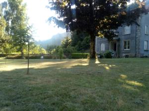 a tree in a yard next to a house at Villa Signerose - chambres chez l'habitant au cœur de l'Ardèche - Hautes vallées in Le Cheylard