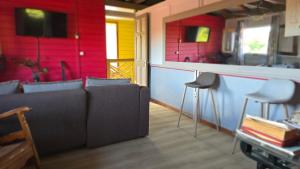 a living room with a couch and a bar with stools at Kay Lydie in Saint-Joseph